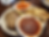 Plate with meatloaf, fries, carrots, and a bowl of red sauce on a wooden table. The setting is simple and casual dining.