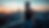 Man in headphones on rooftop at sunset, wearing a tank top and shorts, gazing at city skyline with a calm, focused expression.