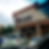 Cars parked outside Pizza Patrón on a cloudy day. The storefront features a logo and "Open" sign. Trees and wet pavement visible.