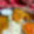 Close-up of a spoon scooping lentil curry from an Indian thali with rice and various colorful dishes on a vibrant patterned cloth background.