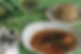 Plate of curry with herbs and red peppers, side of rice, glass of white wine on green table, flowers nearby, elegant dining setting.