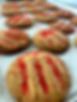 Cookies with red sugar sprinkles, lined on parchment paper. The cookies are golden brown, creating a warm and inviting atmosphere.