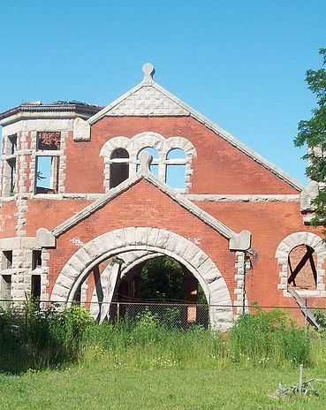 The Lockport train station in its current state on a sunny day. There is greenery growing in front of the station.