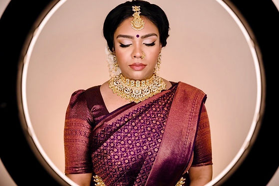 Bride in purple sari with beautiful eyebrows shaped by dil and jewellery