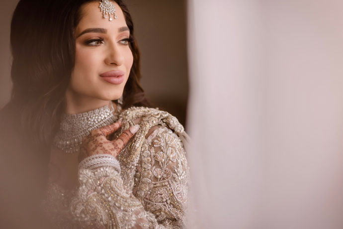 a woman in a suffuse by Sana Yasir looking out a window.