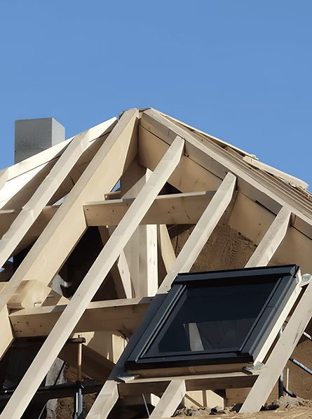 Travaux d'un couvreur charpentier sous un ciel bleu, toiture en rénovation