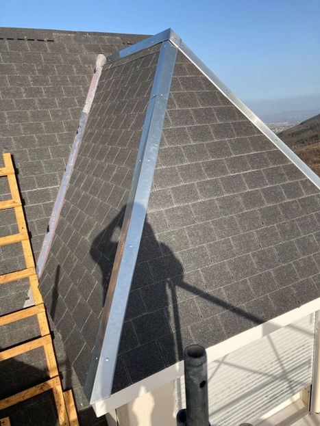 Toiture en ardoise neuve à Saint-Étienne avec arêtiers en zinc et échelle de couvreur visible sur le côté.