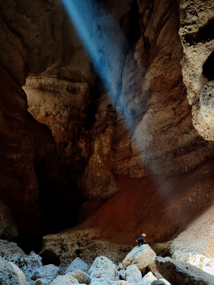 Light beam entering the underground chamber of the 7th Hole cave in Oman
