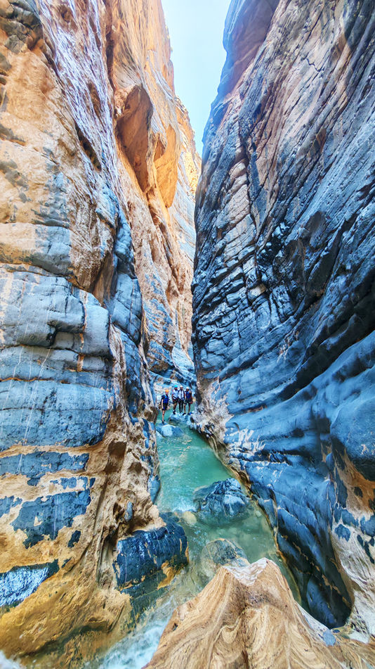 Colorful sculpted rock walls inside Snake Canyon on a canyoning adventure in Oman