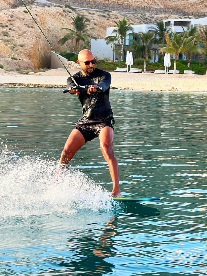 Participant wakeboarding during a four-hour Qantab Islands cruise and water sports experience in Oman