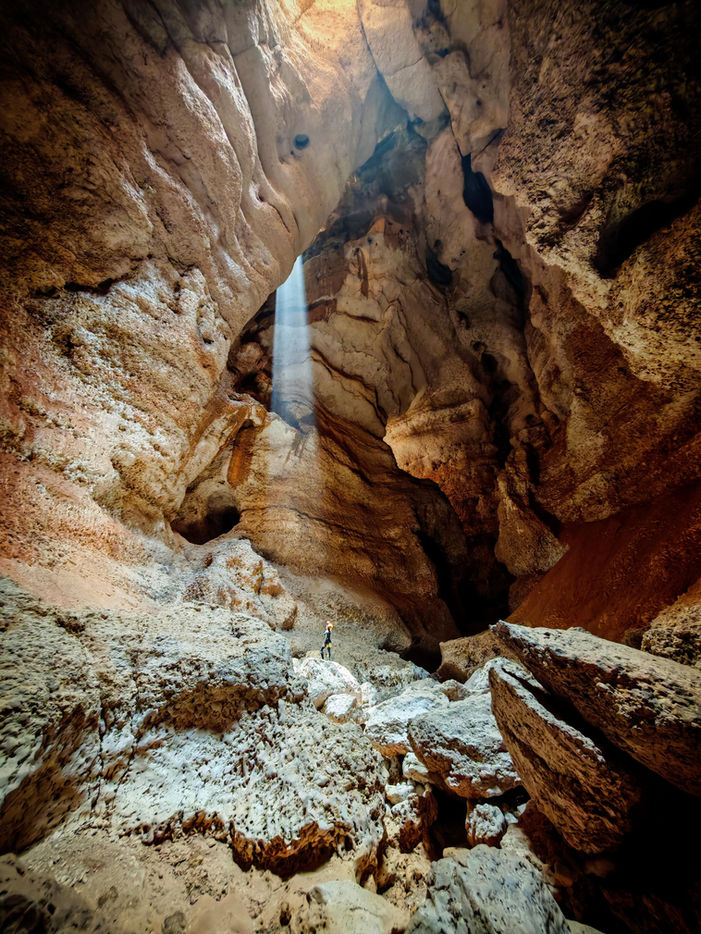 7th Hole cave exploration in Oman with limestone formations and clear pools during a 1-day caving adventure.
