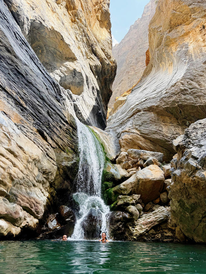 Waterfall cascading through a narrow rocky passage on the Wadi Sa’ada trail in Oman