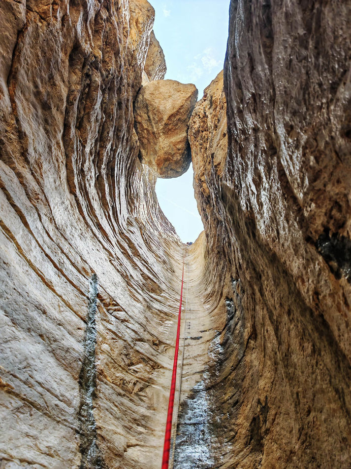 Rope line through sculpted slot canyon walls during the Wadi Qasha canyoning tour in Oman