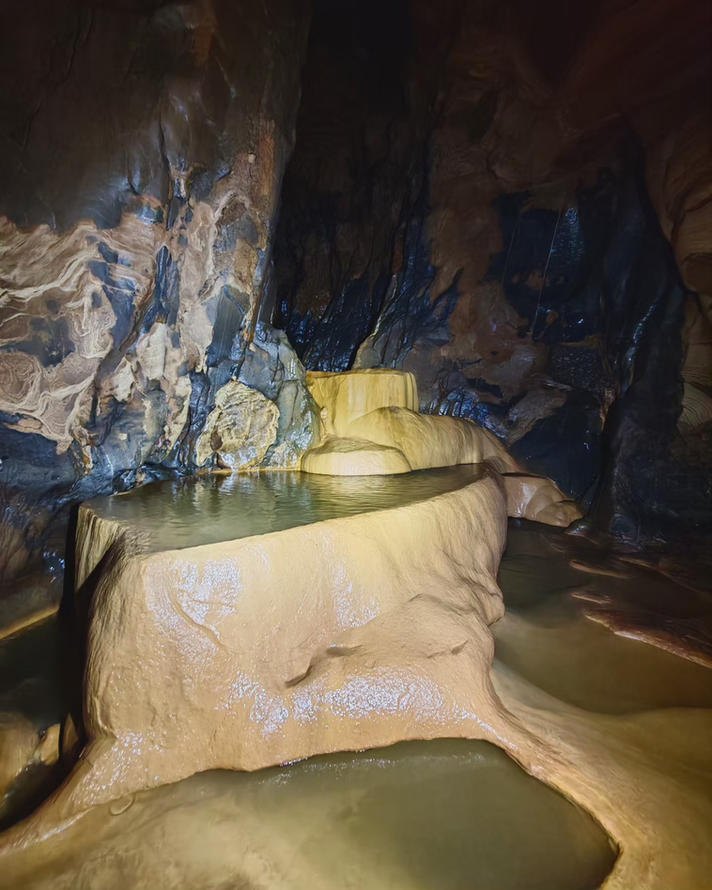 Natural cave pools and smooth limestone formations inside Al Hoota Cave, Oman