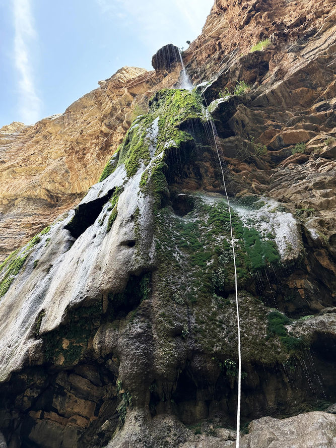 Abseiling beside a waterfall during the Wadi Qasha 1.5-day canyoning adventure in Oman