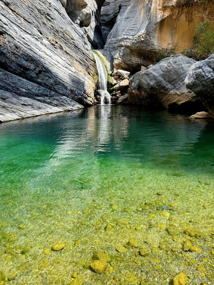 Wadi Sa’ada hiking adventure in Oman with rocky wadis, streams, and mountain views on a 1-day tour.
