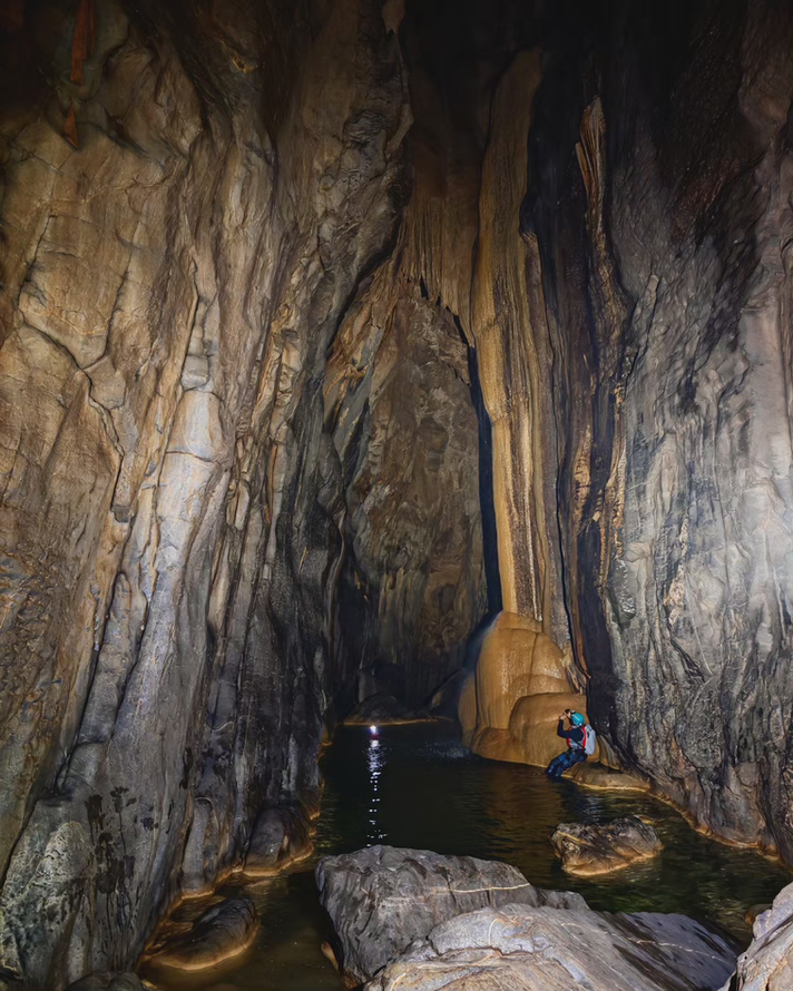 Towering cave formations inside Al Hoota Cave during a one-day caving adventure in Oman