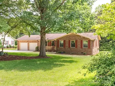 Fresh mulch, tree trimming, and Flowers for a pressure washed Brick House
