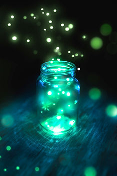 fireflies in a glass jar on a dark backg