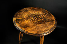 3 legged oak side table with jack daniels shown on the top