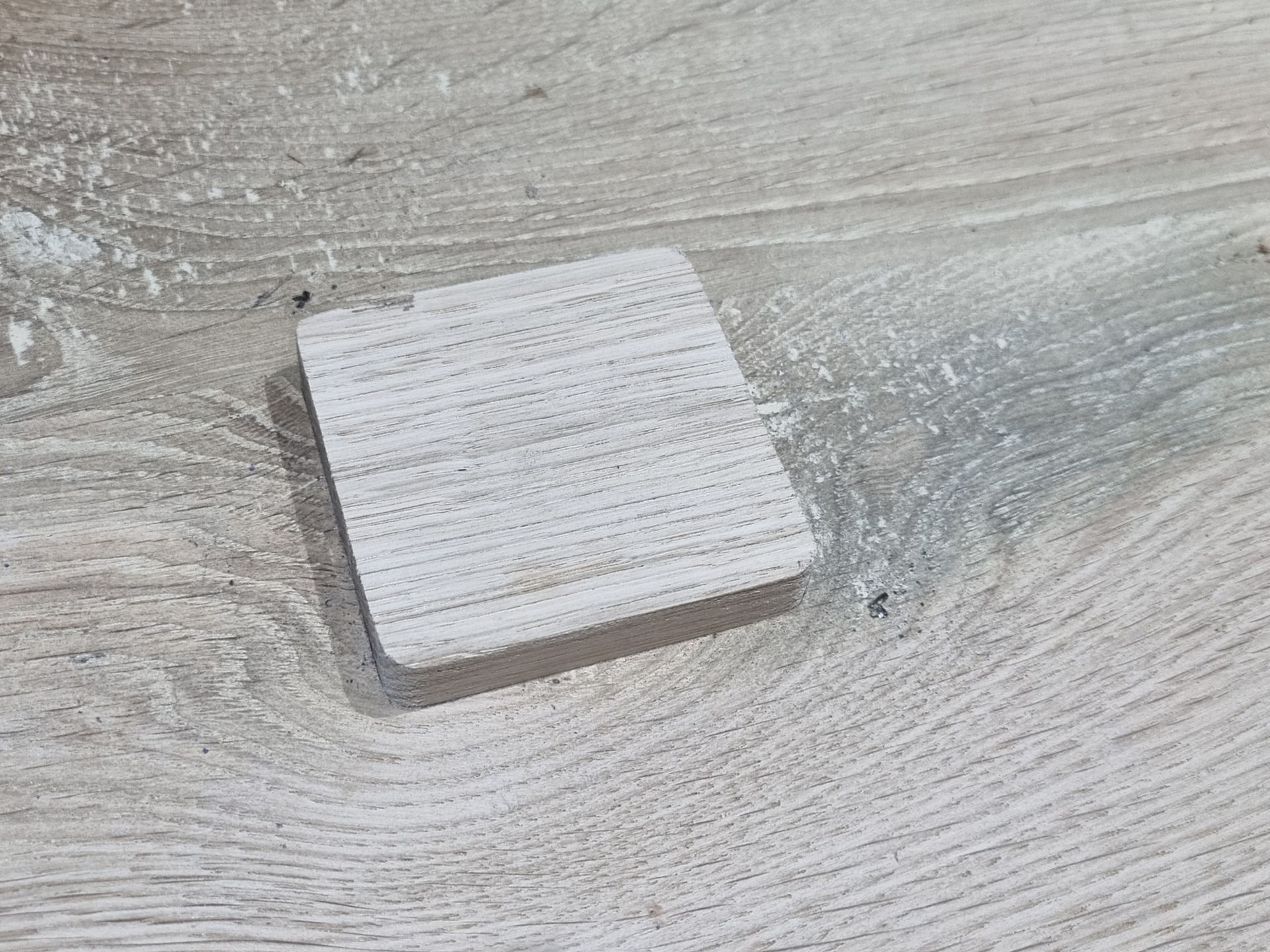 a slightly raised square oak patch inlaid into an oak piece of wood  