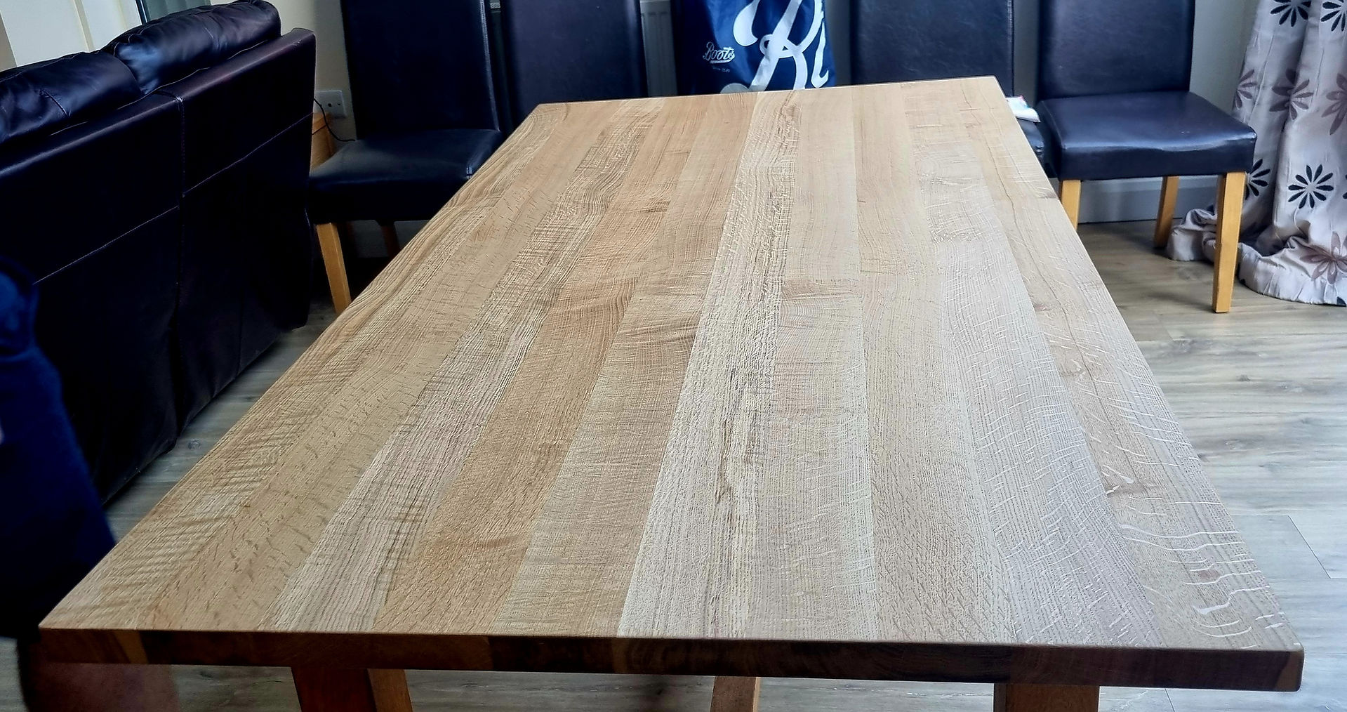 A restored oak dining table with a smooth, even veneer, showcasing the results of the repair.