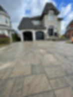 Une entrée de maison entièrement pavée avec du pavé uni installé