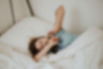 Woman in bed holding her jaw in pain