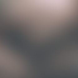 woman sleeps in bed with dark grey and earth toned sheets