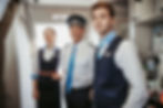 Pilot and flight crew standing at the aircraft entrance