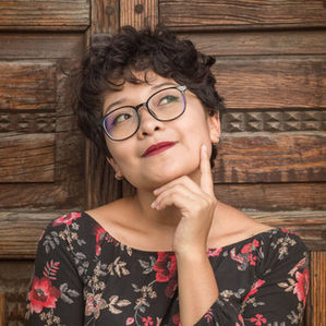 woman wearing glasses and red lipstick looking pensive
