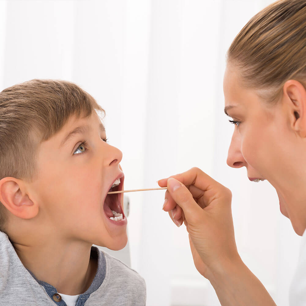 Nurse checking a child’s throat.