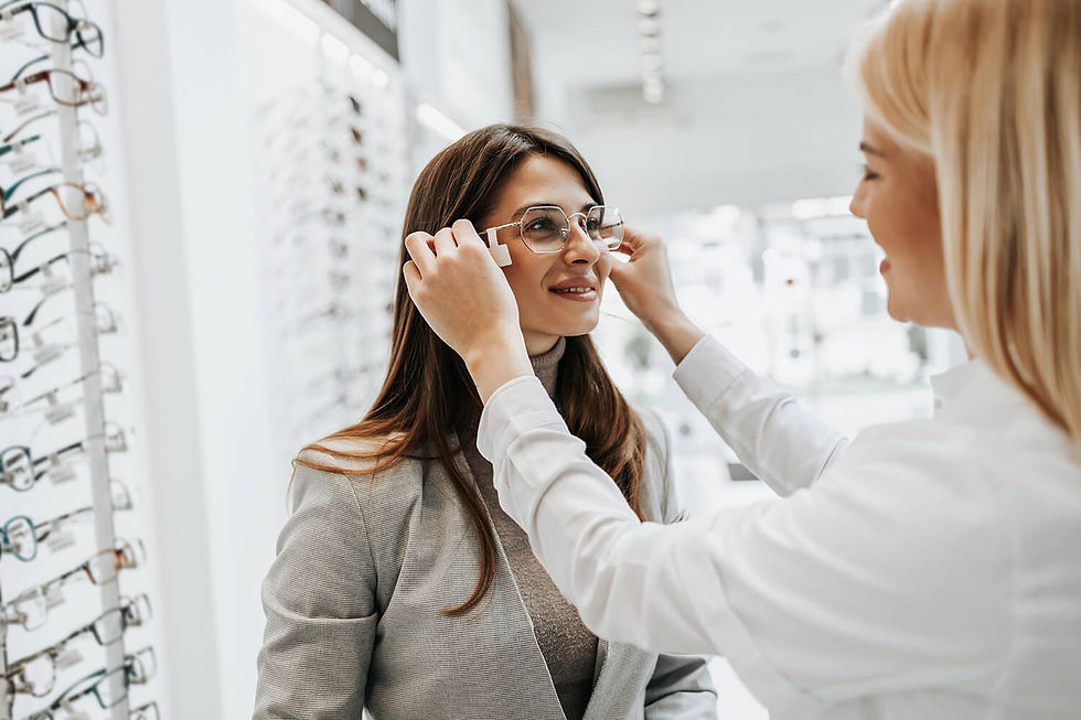 Optometrist fitting glasses on a woman to ensure proper fit