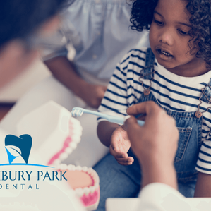 young black girl gets shown by a dentist how to properly brush her teeth
