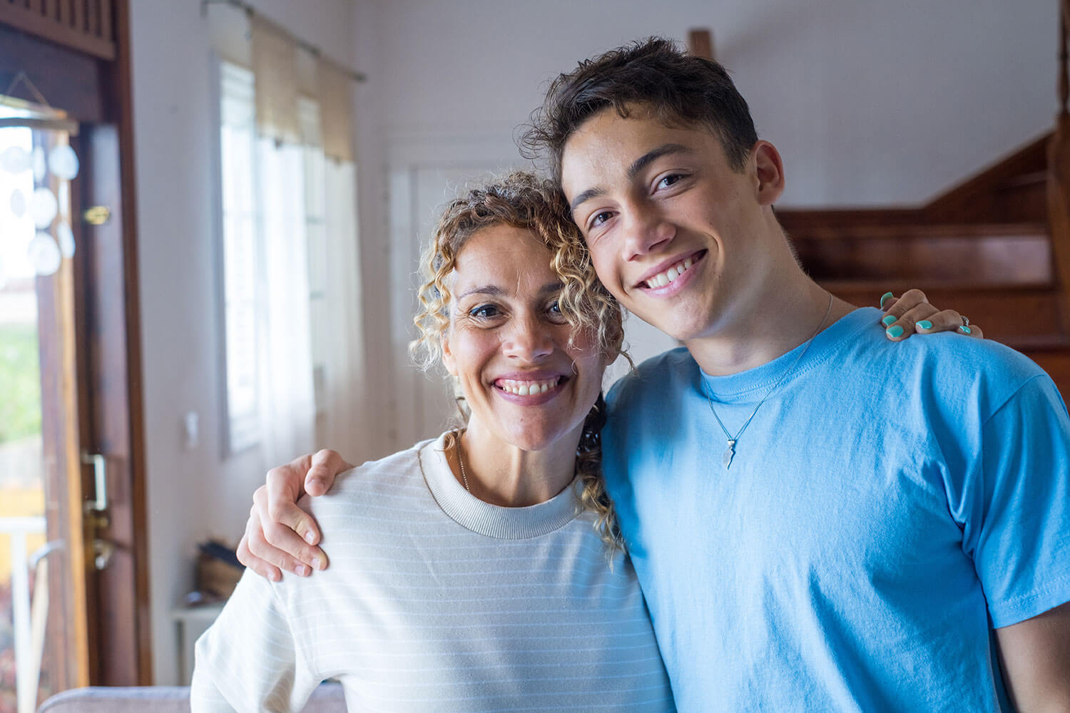Smiling teenager and his mother together