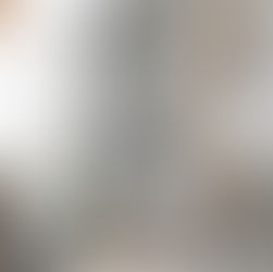 Elegant bathroom with glass shower, gold fixtures, and marble accent wall. Neutral towels hang nearby; serene and modern ambiance. freestanding tub, marble shower, marble slab, porcelain slab, gold bathroom fixtures, white shutter, charcoal tile, primary bathroom