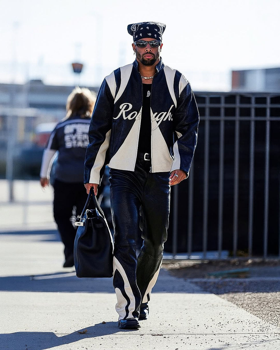 Brandon Jones walking on a sidewalk wearing a black and white leather racing jacket and pants set with a black bandana on his head