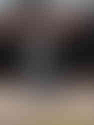 An NFL player walking on a sidewalk wearing a denim checkerboard jacket and pants set