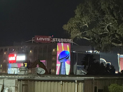 Levi's Stadium at night with a Super Bowl poster featuring the Lombardi Trophy