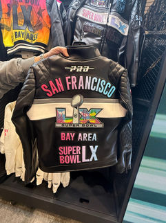 The back of a black moto jacket that has the colorful Super Bowl LX logo on it
