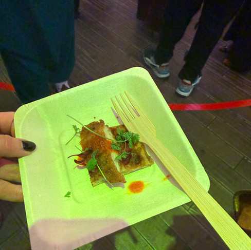 A square paper plate with a strip of chicken and a plantain waffle