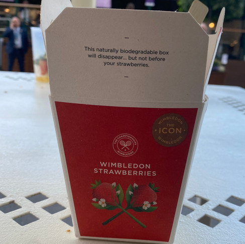 A white paper box with one side colored red that says "Wimbledon Strawberries" in white