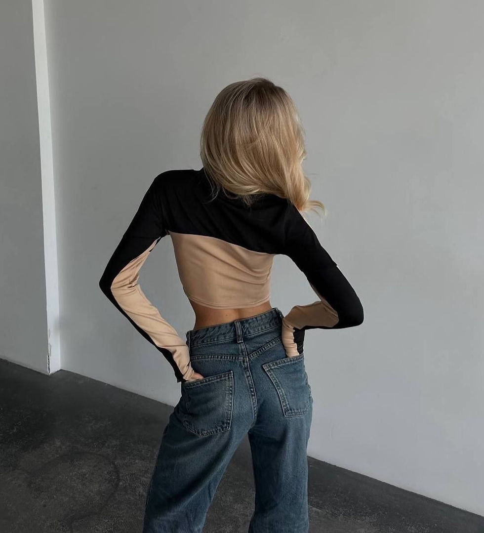 Жінка в чорному короткому топі та джинсах