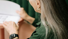 woman in green shirt reading over papers