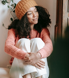 satisfied looking woman sitting on bed