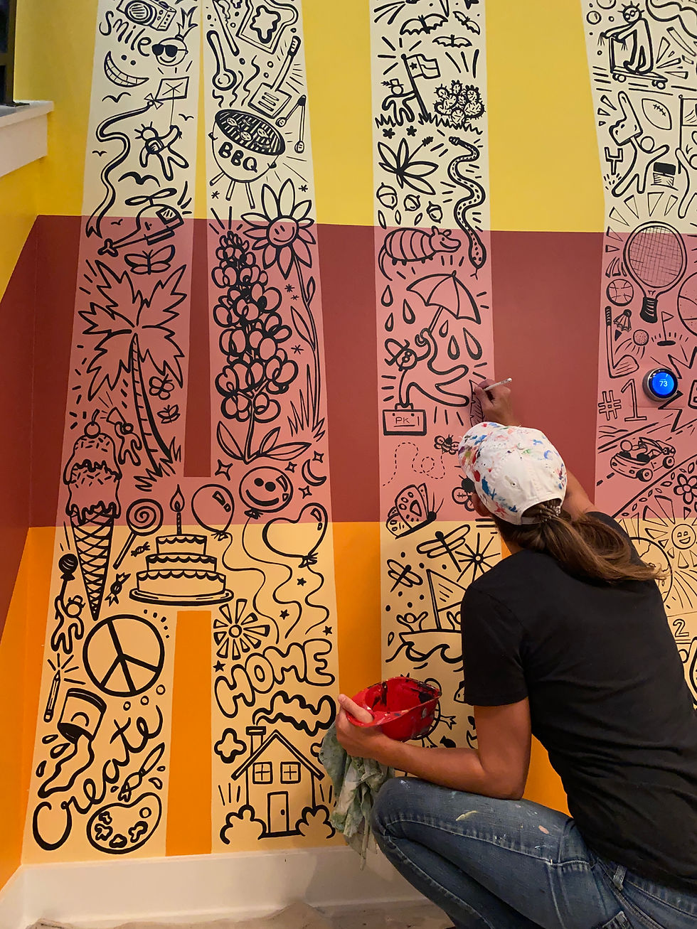 A picture of Sara Mack painting the final touches on an "ATX" mural.
