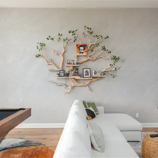 Alabaster Carrera Venetian plaster accent wall in Leander TX with custom hand troweled texture and a custom carved tree bookshelf.