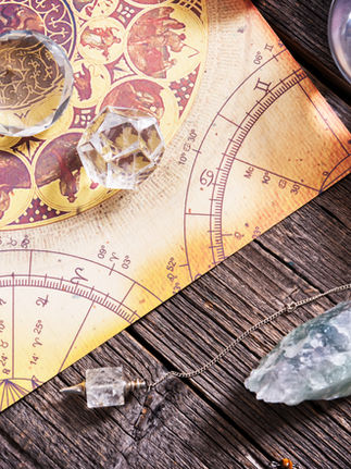 Astrology elements and modalities chart with crystals and candles, illustrating how zodiac signs, elemental energies, and astrological modalities influence personality and birth chart interpretation.