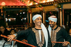 Two men in traditional Egyptian attire perform a joyful dance on a Nile cruise