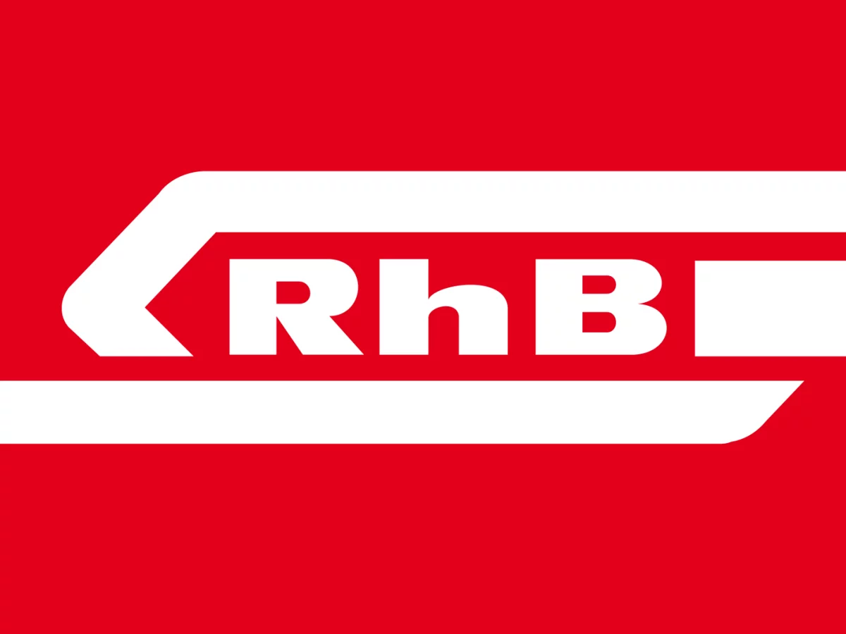 Das Bild zeigt das Logo der RhB. Es ist weiss rot
